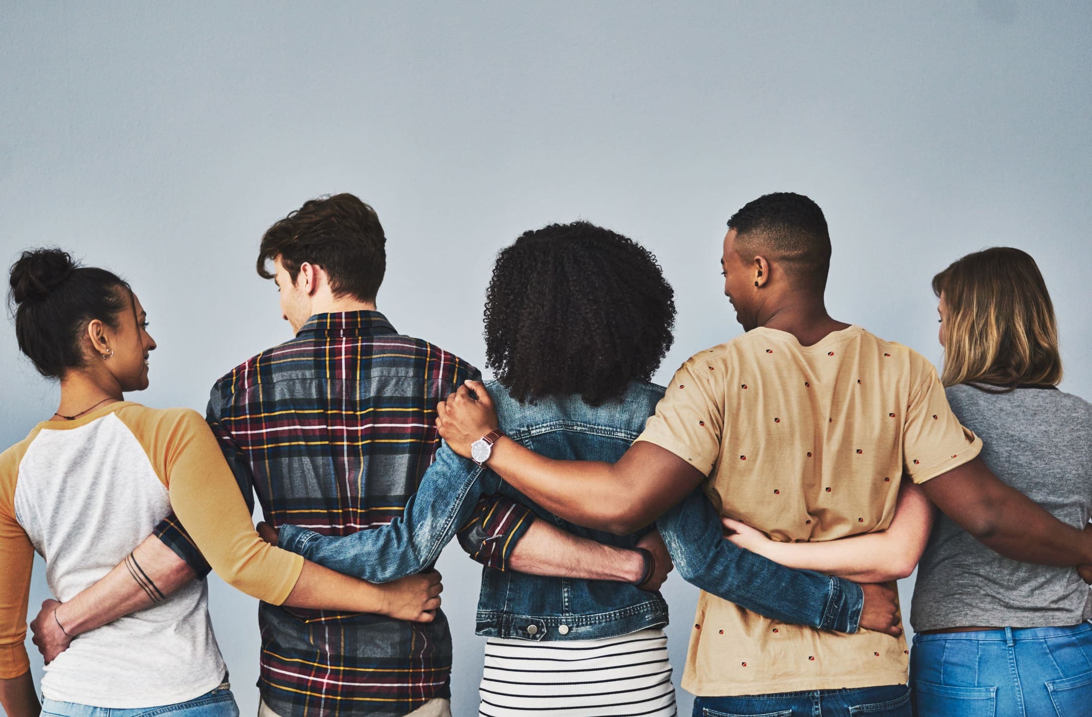 Friends standing arm in arm